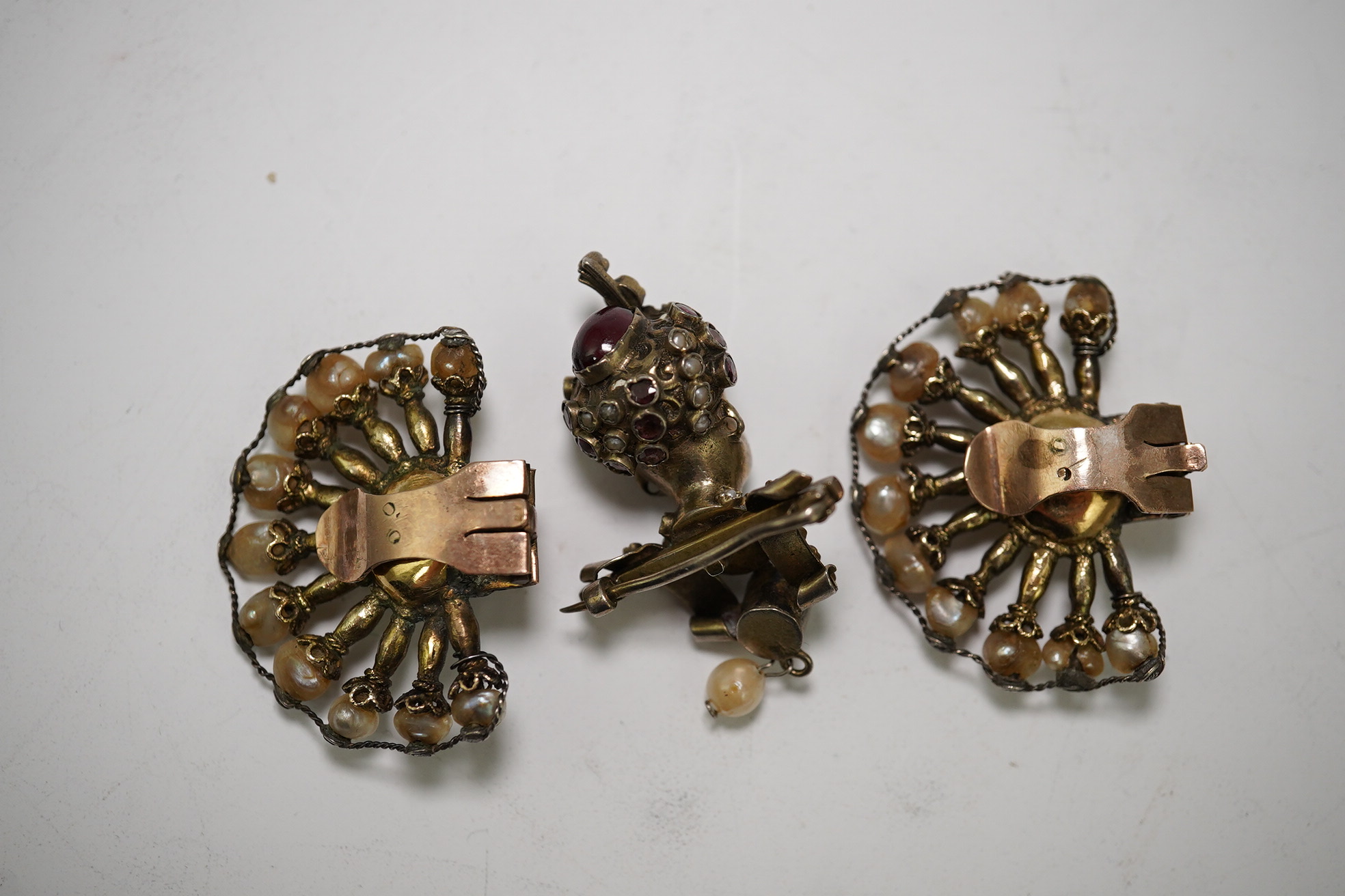 A pair of Indian ruby and baroque pearl set fan shaped ear clips, 42mm and a garnet and seed pearl set turbaned head brooch